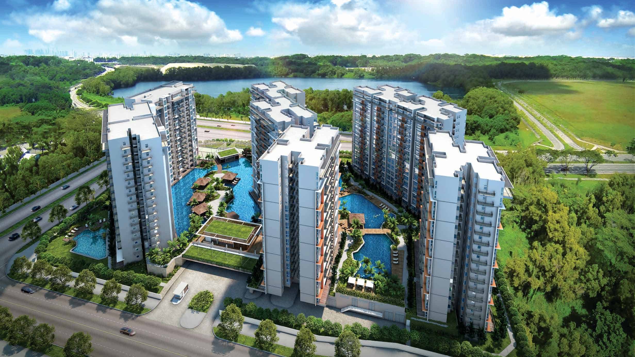 Aerial view of Qbay Residences showcasing the full layout of the development, including multiple high-rise residential towers surrounding a series of lagoon-style pools, landscaped decks, and recreational pavilions, with lush greenery and Bedok Reservoir in the background.